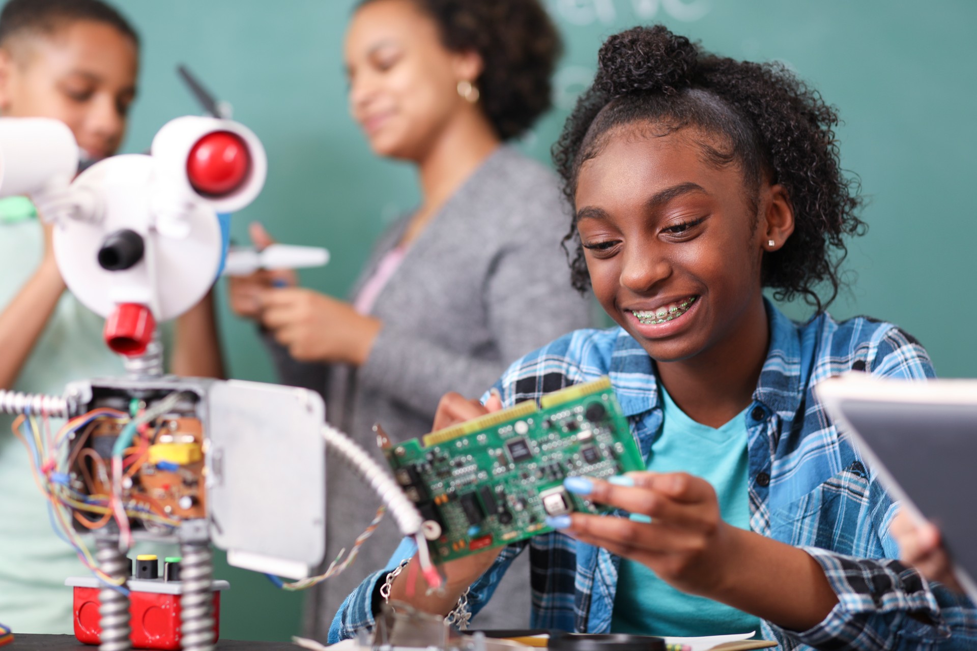 Junior high school age school students build robot in technology, engineering class.